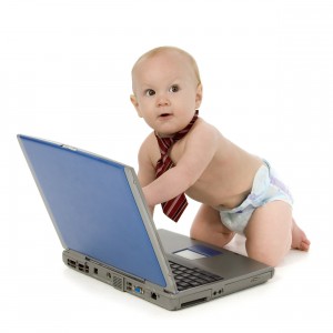 A baby playing with a laptop