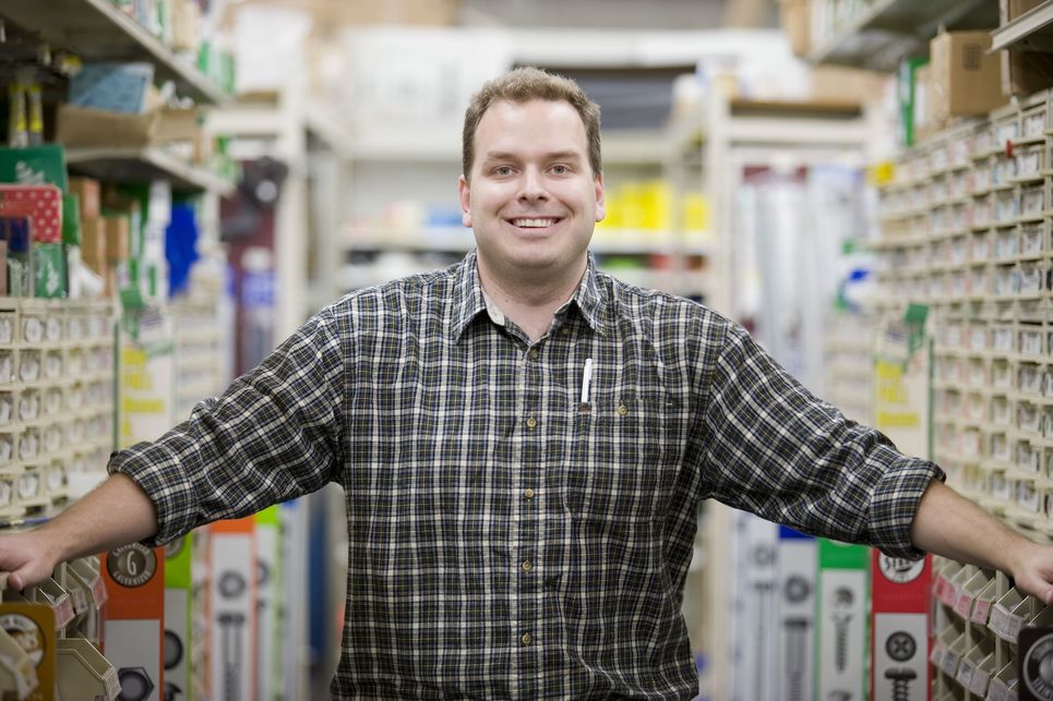 A man standing in a warehouse with shelves full of items.