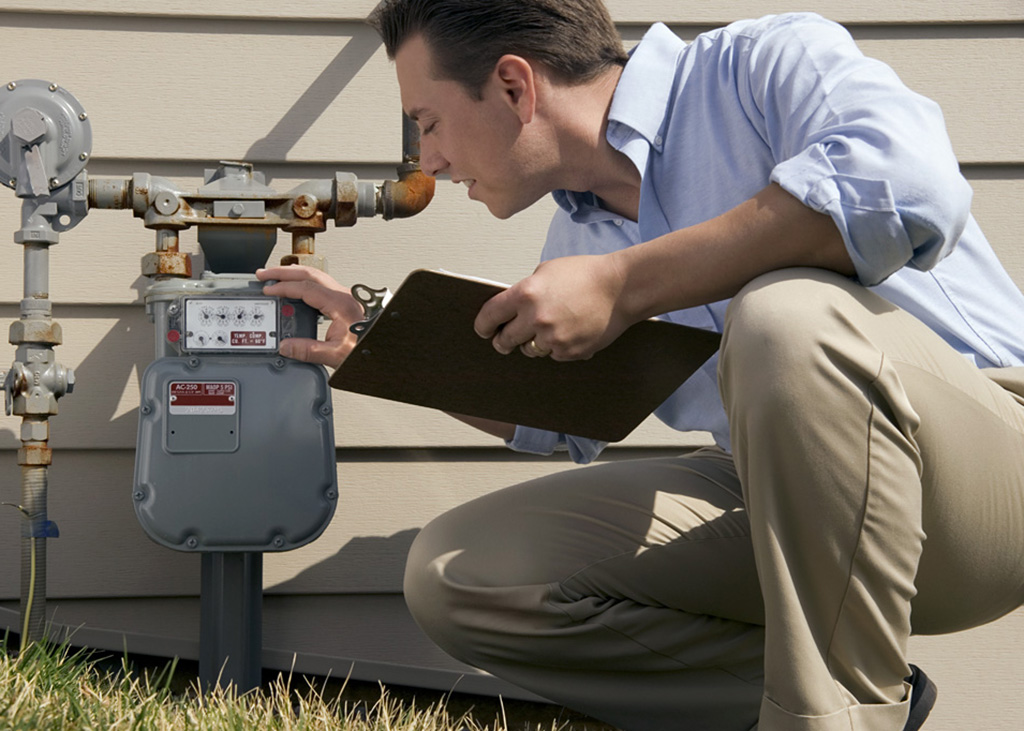 A man inspecting a water meter.