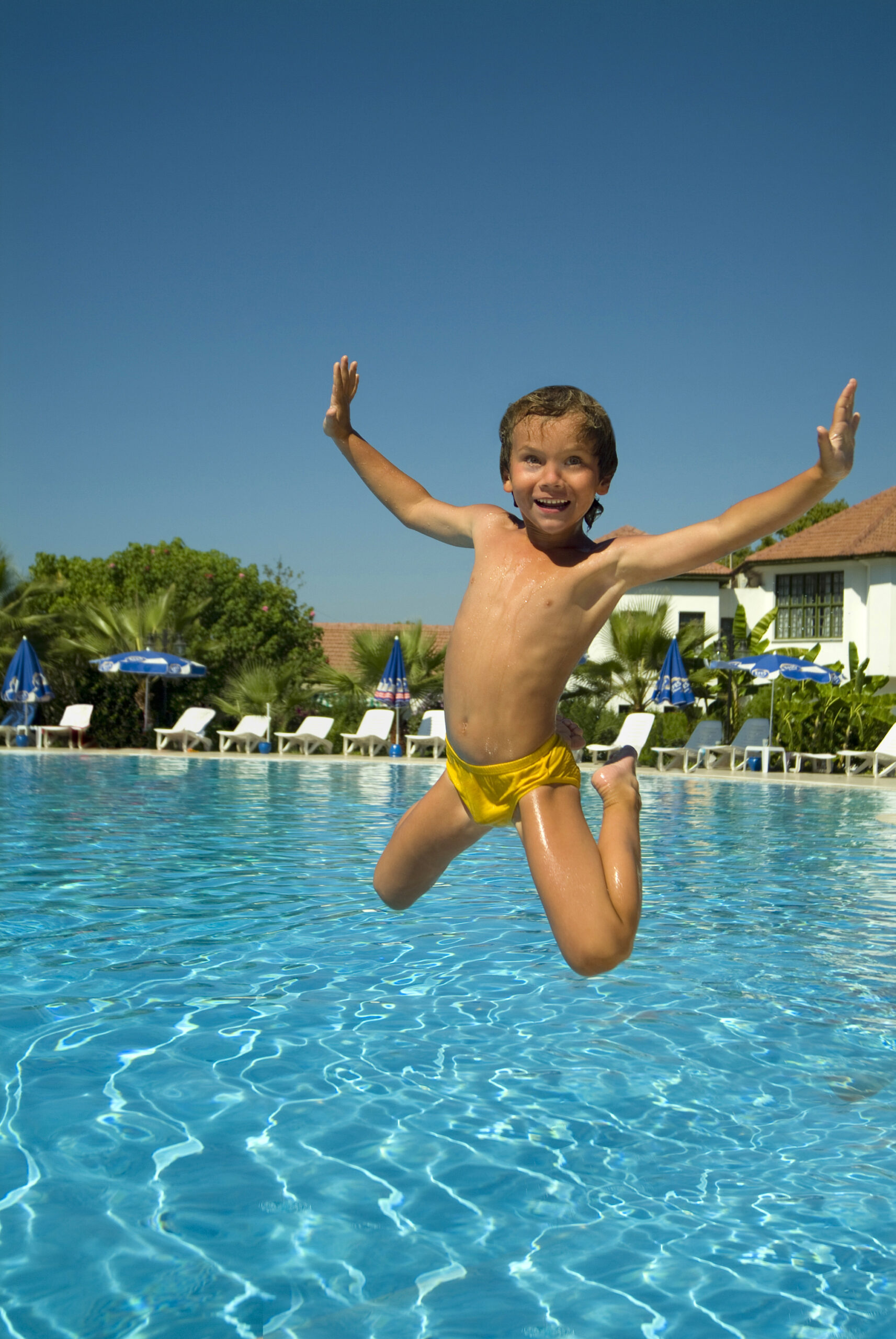 A boy enjoying a refreshing swim in a swimming pool.