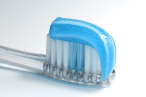 A toothbrush with blue bristles on a white background.