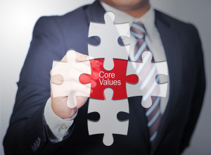 A businessman holding a puzzle piece with the word care values.