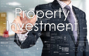 A businessman pointing to the word property investment.