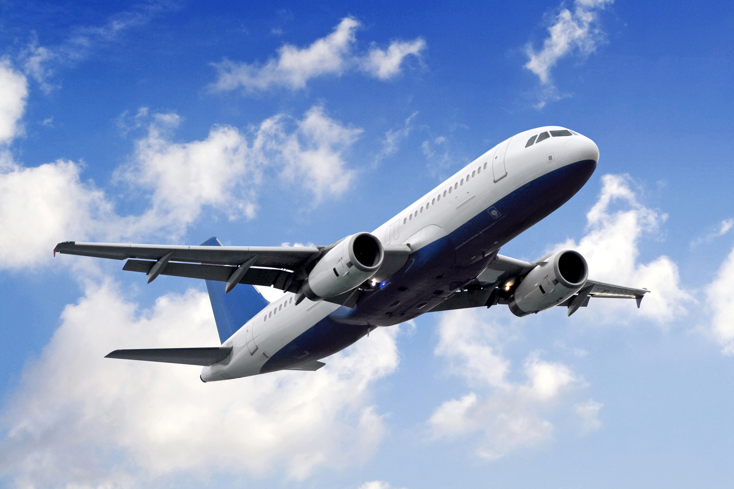 A blue and white airplane flying in the sky.