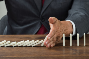 A businessman is putting dominoes on a table.