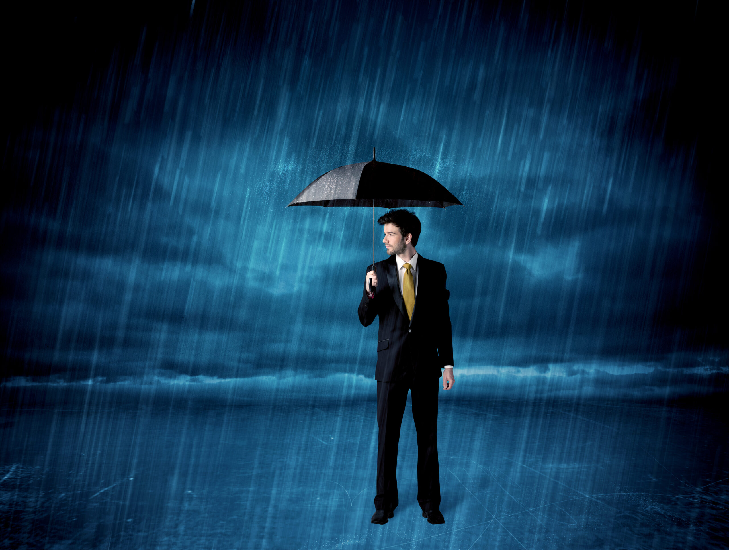 A man holding an umbrella in the rain.