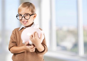 A young boy holding a piggy bank.