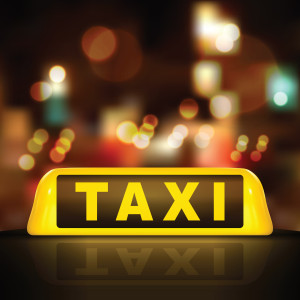 A yellow taxi sign on a dark background.