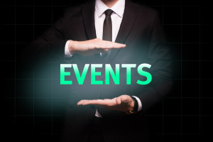 A businessman in a suit holding a glowing sign that says events.