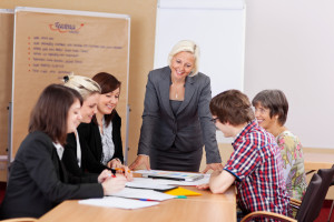 A group of people sitting around a table in a meeting room.