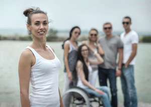 A group of people standing around a person in a wheelchair.