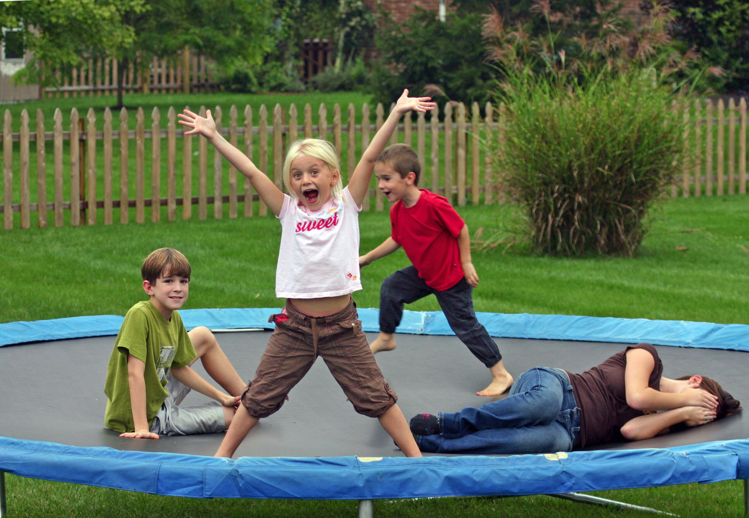 A group of kids playing on a trampoline.