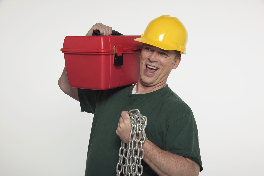 A construction worker holding a toolbox and chain.