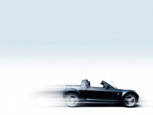 A black sports car in motion on a white background.