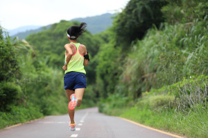 A woman jogging on a country road.