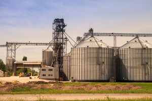 A grain silo in the middle of a field.