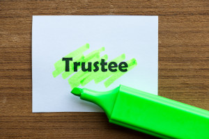 A green marker next to the word trustee on a piece of paper.