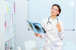 A female doctor looking at an x - ray.