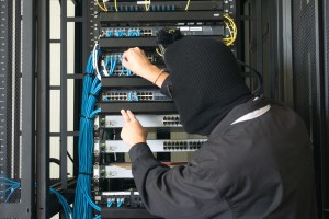 A man in a black hoodie is working on a server.