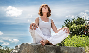 A woman meditating under the open sky