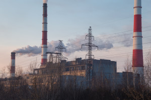 A factory with smoke coming out of the chimneys.