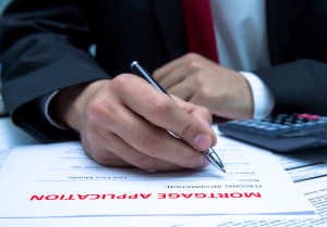 A man in a suit writing on a piece of paper.