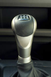 A gear shift in a car with a leather cover.