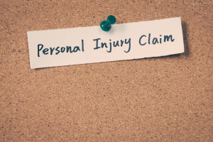 A piece of paper with the word personal injury claim pinned to a cork board.