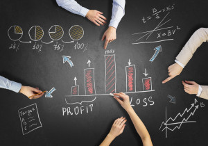 A group of business people pointing at a chalkboard.