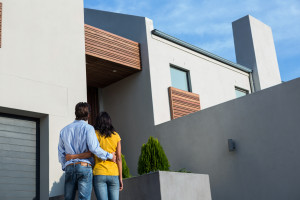 A couple standing in front of a modern house.