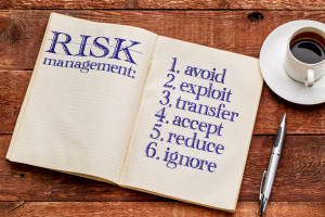 A book with the word risk management next to a cup of coffee.