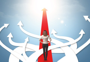 A business woman standing on a red arrow with arrows pointing in different directions.