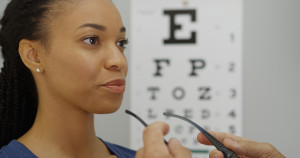 A woman is looking at an eye chart.