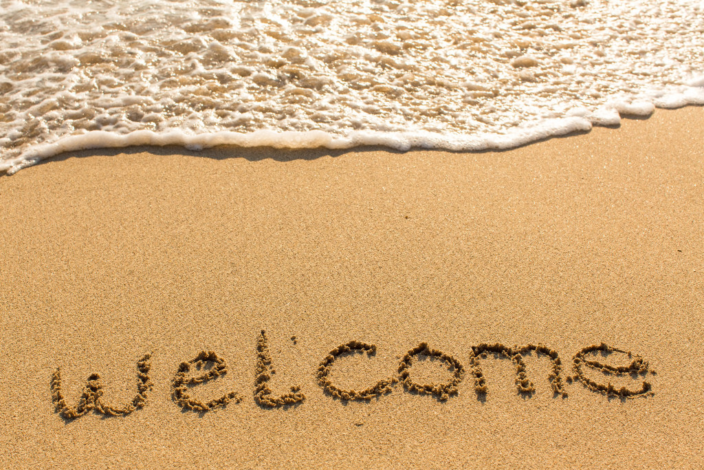 A Welcome Sign Marked on Sand of a Beach