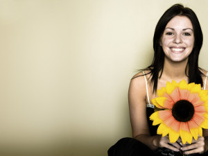 A woman with a paper sunflower in her hand