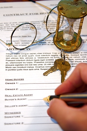 A person signing a real estate contract with a pen and glasses.