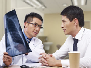 Two doctors looking at an x - ray.