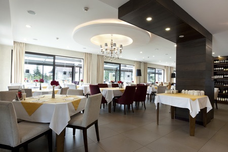 A restaurant with white tablecloths and wine glasses.