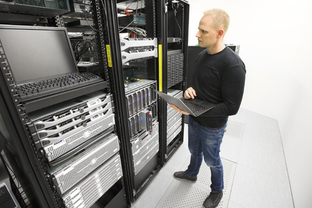 A man standing in front of a server rack.