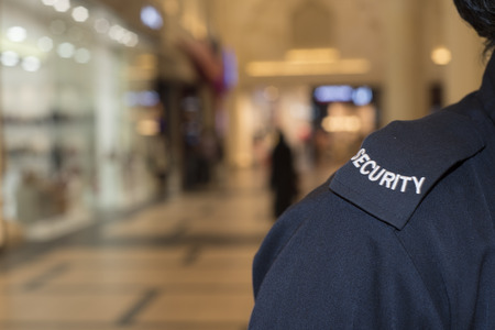 A security guard wearing a uniform in a shopping mall.