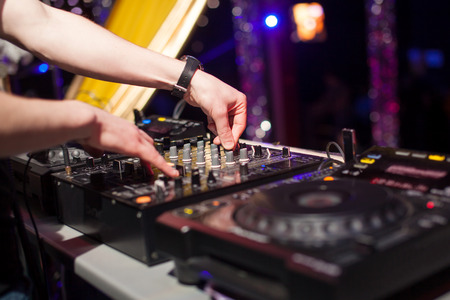 A dj is mixing on a turntable at a party.