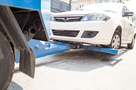 A car is being towed by a tow truck.