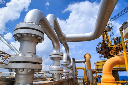 Pipelines in an oil field with a blue sky.