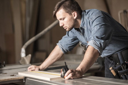 A carpenter is working on a piece of wood.