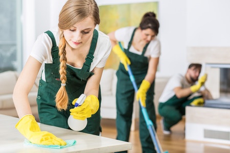 A group of women cleaning a house with a mop.