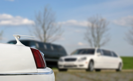 A white limo is parked in a parking lot.