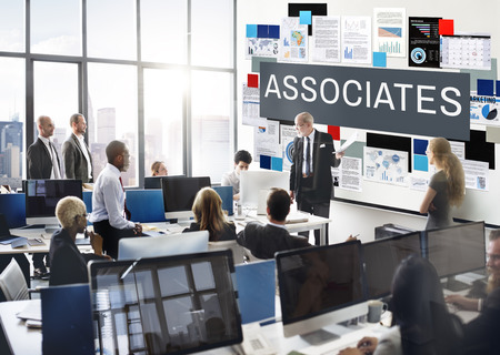 A group of people in an office with the word associates on the wall.