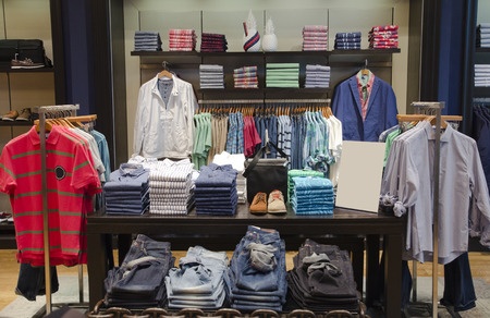 A men's clothing store with a variety of shirts on display.