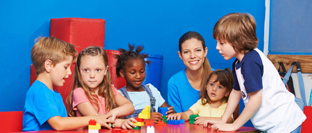 A group of children playing at a table in a classroom.