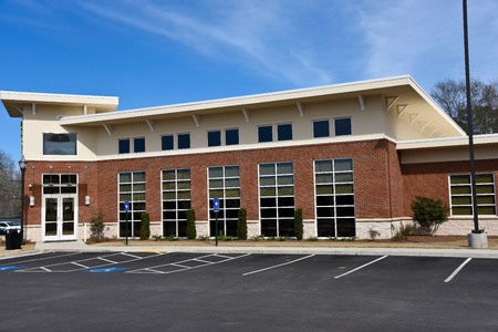 A brick building with a parking lot in front.